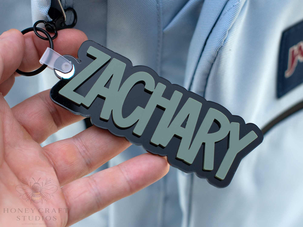 Custom acrylic keychain in fern green with name of "Zackary," used as backpack tags, party favors, and personalized gifts.