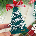 Decorative Christmas tree ornament with 'The Downey Family 2025' text and a red and white bow.