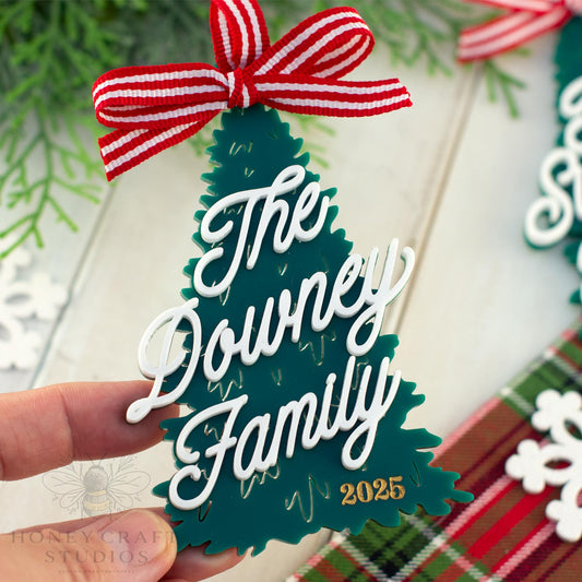 Decorative Christmas tree ornament with 'The Downey Family 2025' text and a red and white bow.
