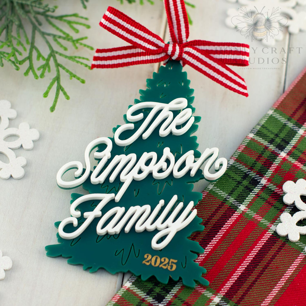 Christmas tree-shaped ornament with 'The Simpson Family 2025' text on a plaid fabric background.