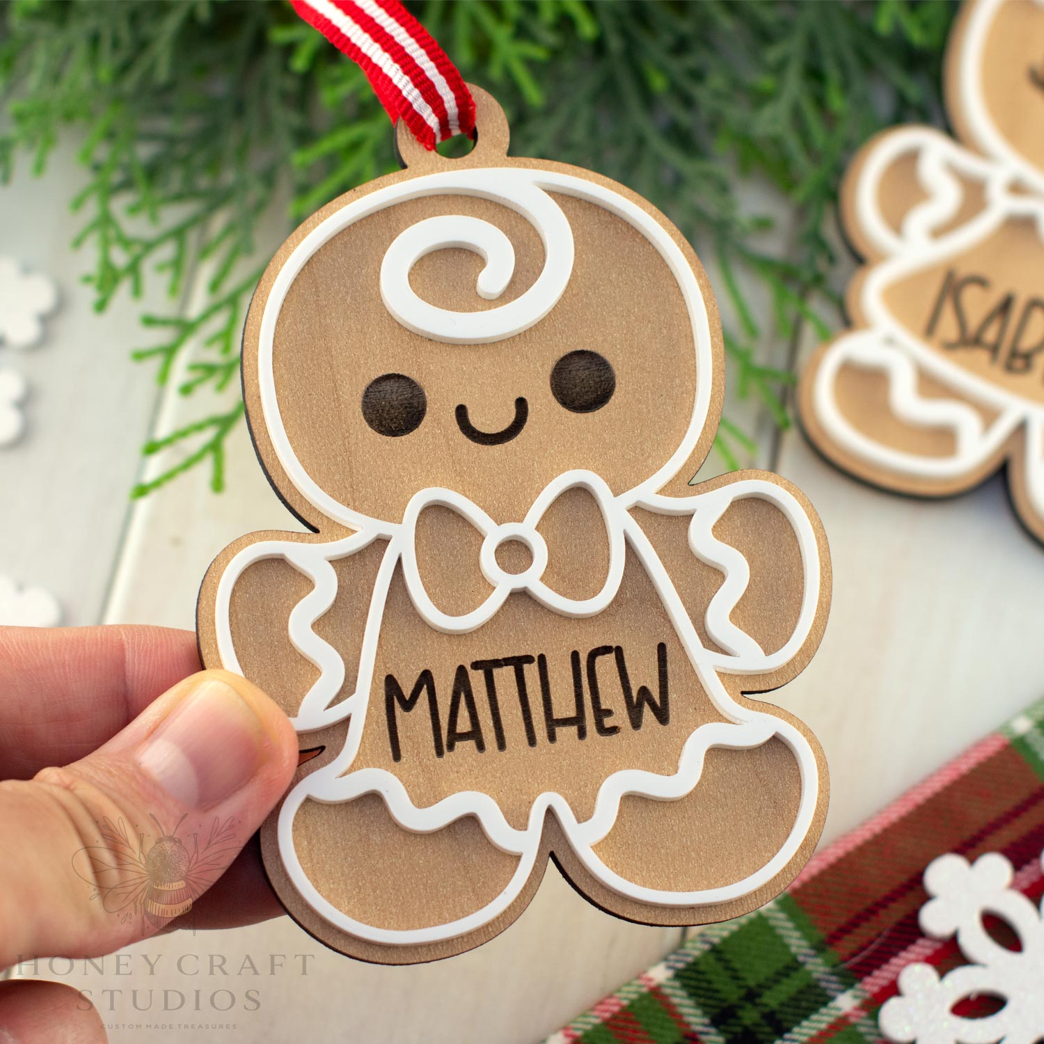 Gingerbread man ornament with 'MATTHEW' on a Christmas tree background