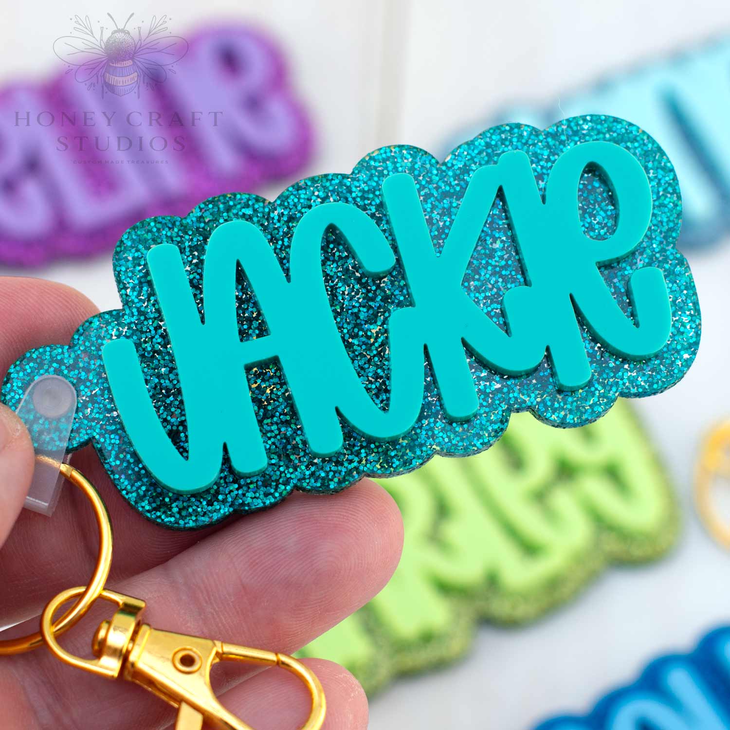 Teal glitter acrylic keychain with personalized name in bold letters, perfect for sports bags and backpacks.