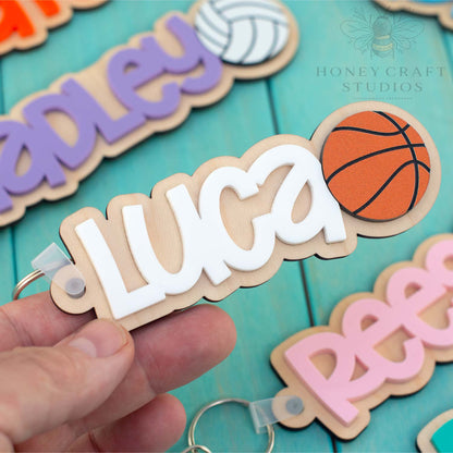 Personalized basketball name tag keychain with white acrylic name on wood backing and basketball design