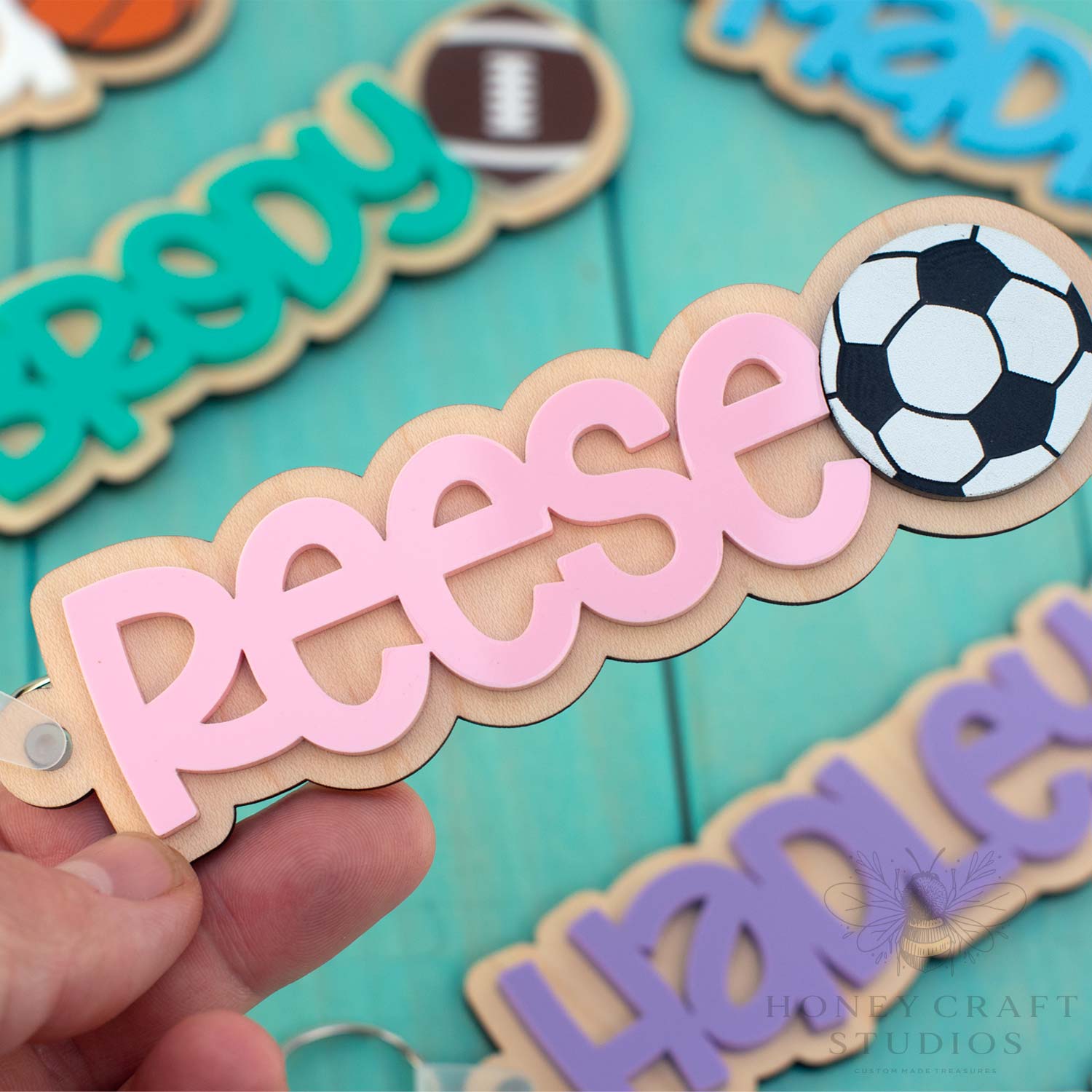 Personalized soccer name keychain with pink acrylic lettering on wood base and soccer ball detail