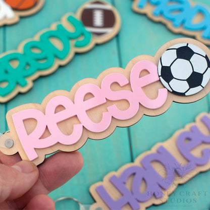 Personalized soccer name keychain with pink acrylic lettering on wood base and soccer ball detail