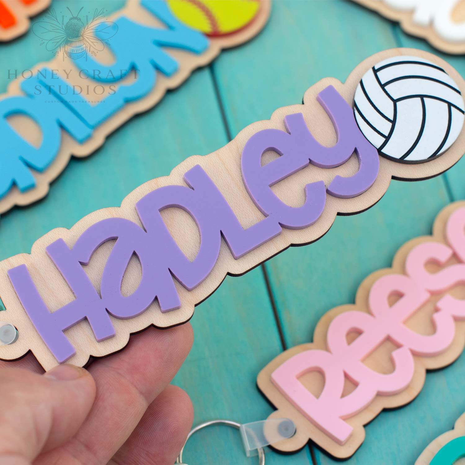 Personalized volleyball name keychain with purple acrylic lettering and volleyball design on wood base