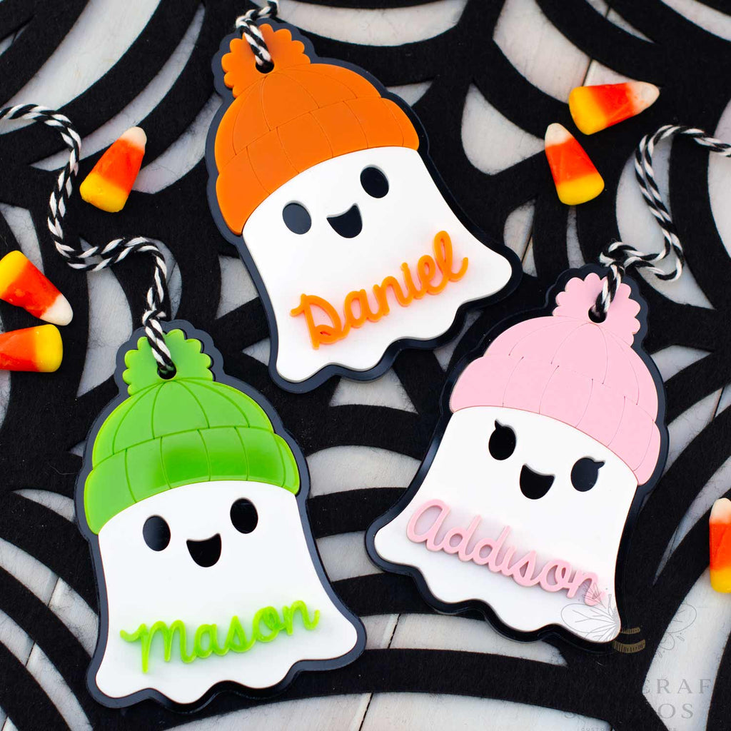 Three Ghost with Beanie Personalized Name Tags in lime, orange, and pink beanies — custom acrylic Halloween basket tags for kids.