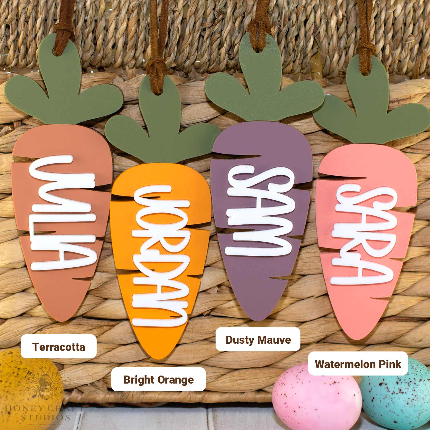 Custom acrylic carrot name tags for Easter baskets showing terracotta, bright orange, dusty mauve, and watermelon pink color options
