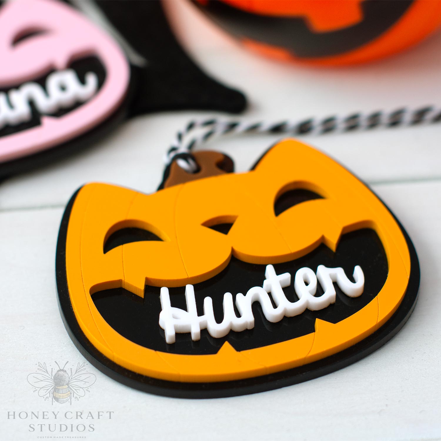 Halloween-themed cat lack-o-lantern keychain with 'Hunter' text on a white surface, branded 'Honey Craft Studios'.