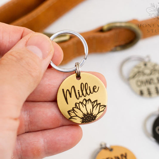 Personalized stainless steel pet ID tag with sunflower engraving and custom name Millie in a gold finish, deep engraved dog and cat tag.