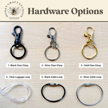 Various hardware options for keychains on a wooden surface with Honey Craft Studios branding.