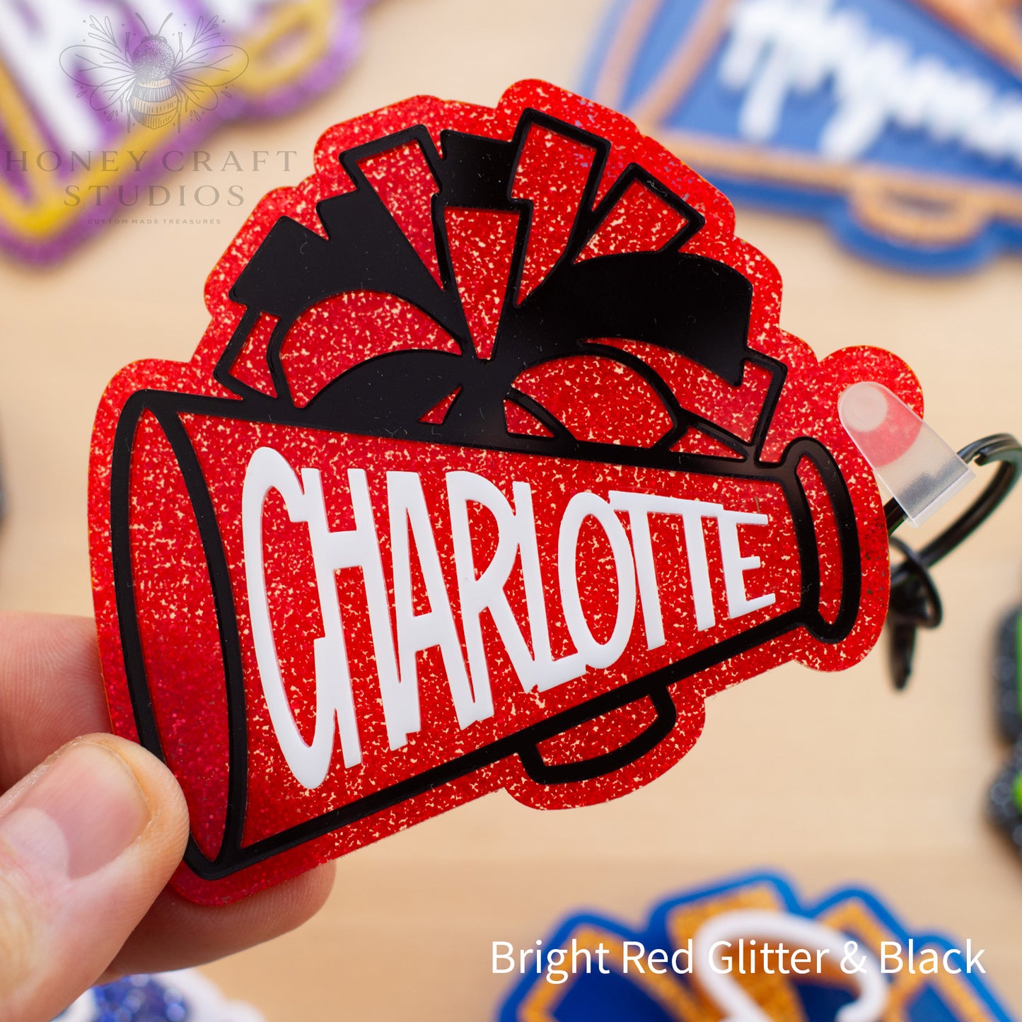 Red glitter cheerleader megaphone bag tag personalized with a custom name and layered acrylic details.