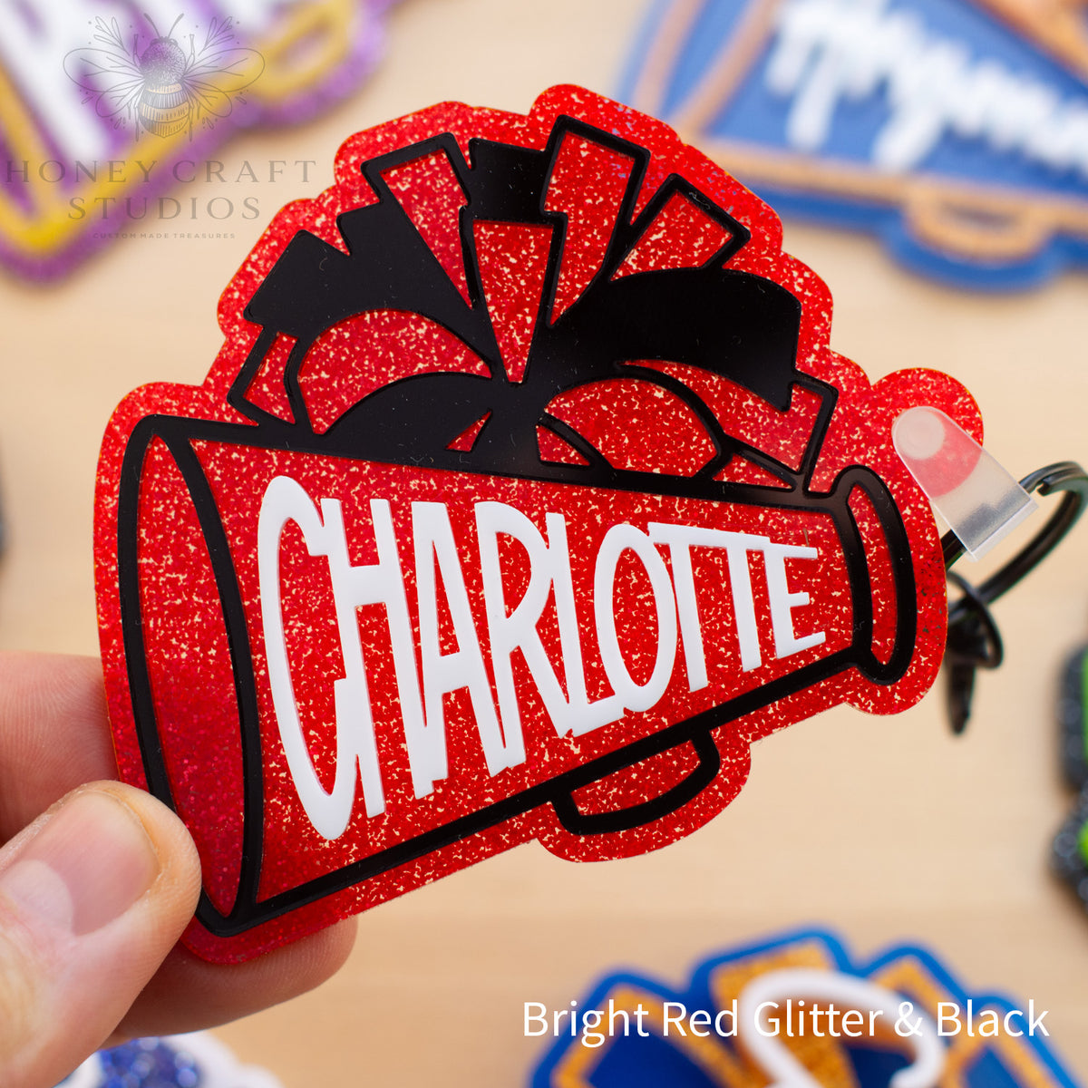 Red glitter cheerleader megaphone bag tag personalized with a custom name and layered acrylic details.