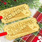 Two Polar Express train ticket luggage tags with red hanging ribbons, displayed on a festive background of pine branches and a red plaid blanket. White dimension lines and text indicate the size of the tags.